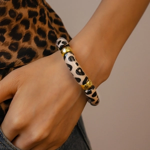 Detail view of elastic acrylic leopard print beads with gold metal spacers on wrist