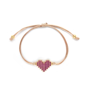 Adjustable beige pearl cord bracelet with a gold heart pendant and pink stones on white background