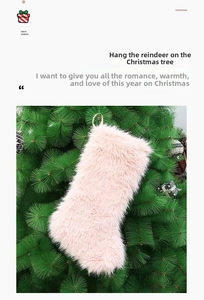 Close-up of a pink faux fur Christmas stocking hanging on a green tree branch