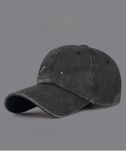 Detailed embroidery of a white mountain peak on a vintage washed dark grey cotton baseball cap