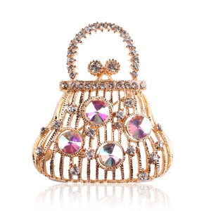 Detailed close-up of a golden handbag brooch with sparkling AB rhinestones and crystals