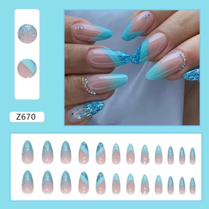 Blue glitter almond press-on nails with silver sparkles and rhinestone accents