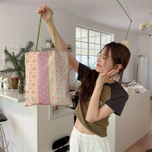 Gros plan sur un sac cabas en toile patchwork fleuri avec étiquette Sozakka