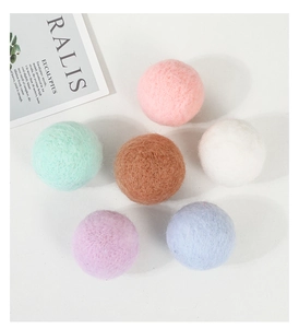 Flat lay of colorful wool felt balls in pastel tones with a minimalist decor card
