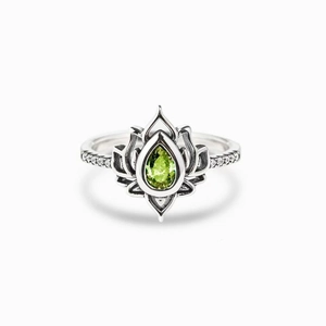 Macro detail of vintage silver lotus ring with pear-cut green gemstone and micro-pavé diamonds