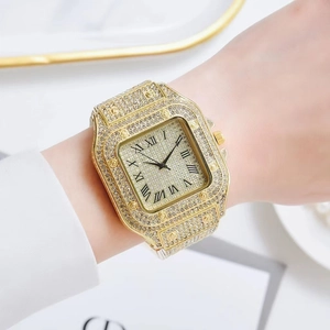 Close-up of a women's gold square watch with a diamond-set bezel and Roman numeral dial
