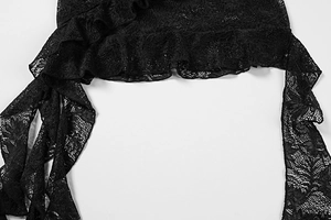 Détail d'une robe en dentelle noire avec broderie florale et bordure à volants