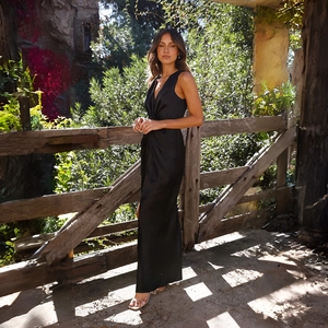 Détail de robe de soirée en satin noir avec col en V profond et fente latérale chic