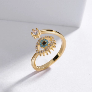 Detailed view of evil eye ring with blue stones and white zircon on golden open band