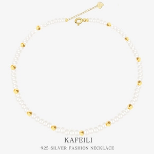Detailed macro of S925 sterling silver chain with white pearls and gold geometric beads