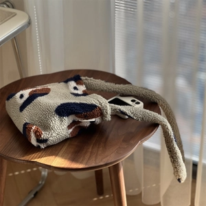 Gros plan d'un sac cabas en polaire pelucheuse avec motif patchwork sur un tabouret