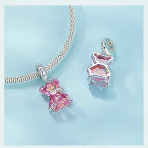 Macro view of pink gradient teddy bear charm with silver-tone metal and sparkling crystals