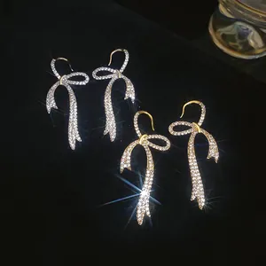 Bow knot dangle earrings with sparkling zircons in gold and silver finish plating