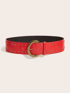Détail d'une ceinture punk rouge en cuir avec boucle ronde dorée et rangées de rivets