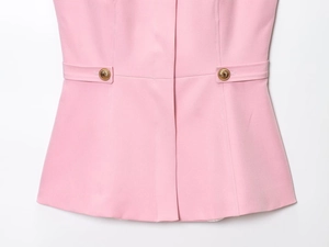 Dettaglio del top rosa con pieghe in vita e due bottoni dorati vintage decorativi