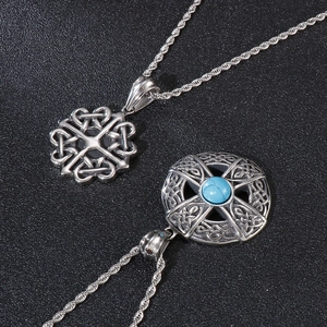 Close-up of Celtic knot pendants with blue turquoise stone inlay on black background