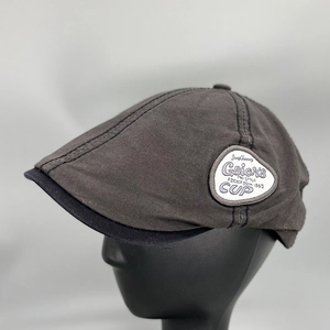 Retro charcoal grey cotton flat cap with side embroidery patch on a display head