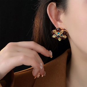 Close-up of vintage floral earrings with colorful gemstones worn by a model