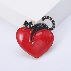 Cute enamel black cat resting on a red heart brooch with elegant gold trim finish