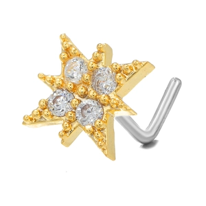 Macro shot of L-shaped gold star nose stud with sparkling cubic zirconia on white background