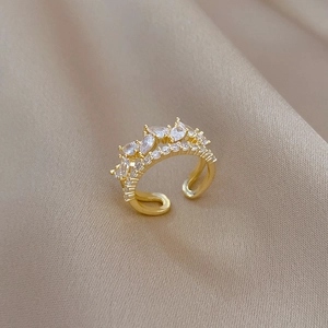 Detailed close-up of a gold teardrop zircon ring on elegant beige silk fabric