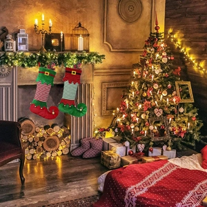 Detail of elf-shaped Christmas stockings with striped patterns hanging on a cozy fireplace