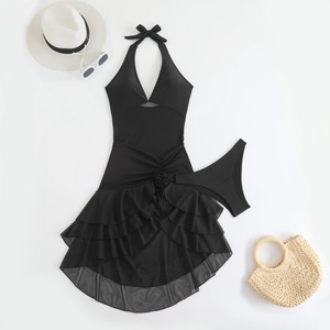 Detail of black halter swim dress featuring 3D floral accent and layered mesh ruffles