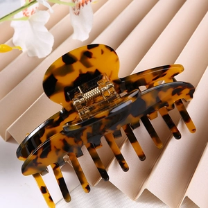 Detailed macro view of amber tortoiseshell claw clip with non-slip metal spring