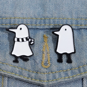 Close-up of minimalist black and white Medjed style enamel pins on denim fabric