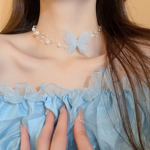 Detailed view of light blue tulle butterfly pendant with rhinestone on pearl necklace