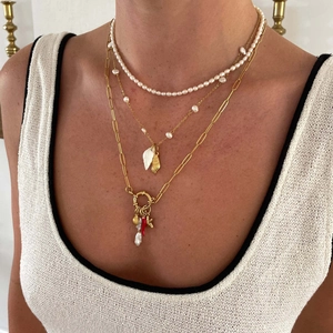 Three-layer layered necklace featuring pearls, shell charms, and a red coral pendant