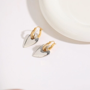 Close-up of heart earrings with two-tone silver and gold plating and zircon inlay