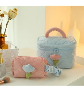 Detailed view of quilted corduroy cosmetic bags with flower zippers in blue and pink