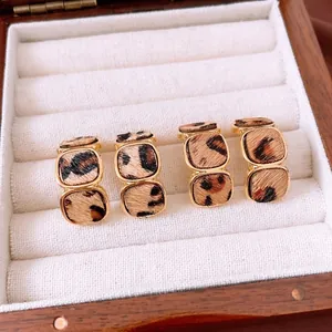 Elegant 18K gold plated geometric leopard print earrings on soft velvet jewelry box display