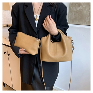 Detail of camel leather bucket bag set showing premium lychee texture on a model