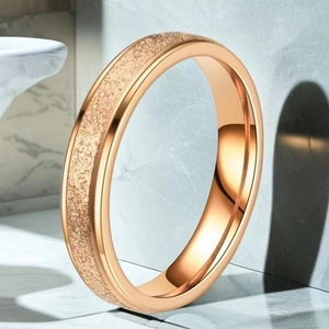 Detail of rose gold minimalist ring featuring stardust sandblasted finish and polished edges