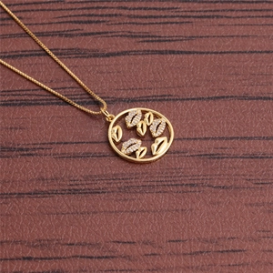 Detailed view of a gold-plated necklace featuring a round pendant with red lip motifs