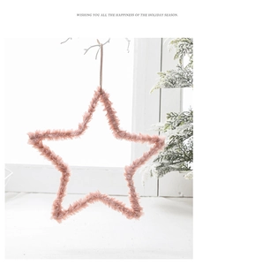 Pink plush star ornament hanging in a cozy winter window scene with snowflake backdrop