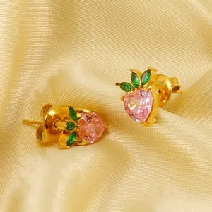 Cute strawberry stud earrings with pink heart zirconia on golden silk background