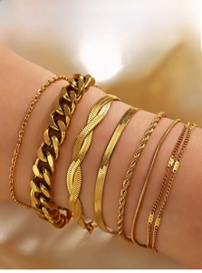 Close-up of stacked 18K gold-plated Cuban and flat snake chains on a model's wrist