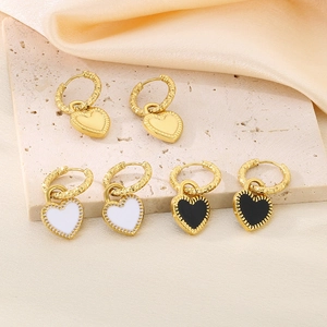 Vue détaillée de boucles d'oreilles cœur plaquées or en finitions noir, blanc et doré