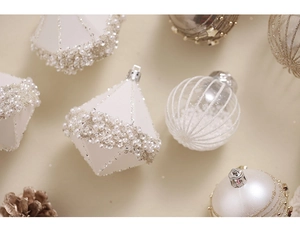 Close-up of champagne and white Christmas ornaments with elegant pearl bead details