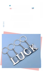 Close-up of polished silver metal LUCK letter keychain with mirror finish and chain