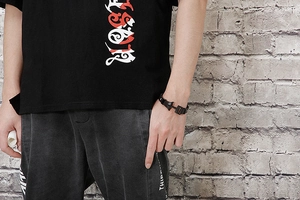 Bracelet ancre en cuir tressé noir pour homme porté avec un style décontracté