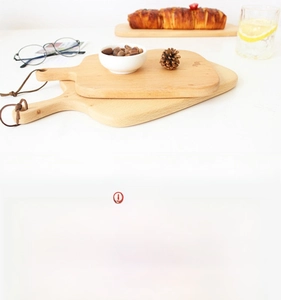 Detail of beech wood cutting board showing wood grain texture and leather hanging strap