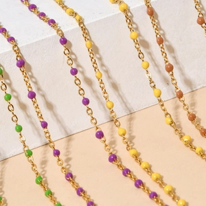 Detail of colorful enamel beads on gold stainless steel chain in french retro style