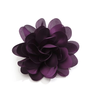 Detailed close-up of dark purple fabric flower brooch with layered satin petals