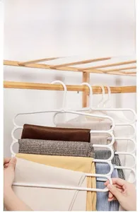 Detail of white five-tier pants hanger showing tiered storage for space-saving in closet