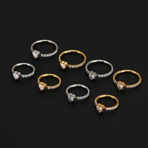 Macro view of eight heart-shaped opal and zircon rings in silver and gold finishes