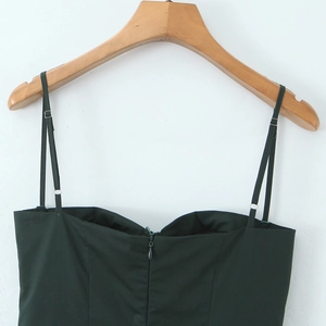Deep green backless maxi dress with thin straps and rear zipper on a wooden hanger